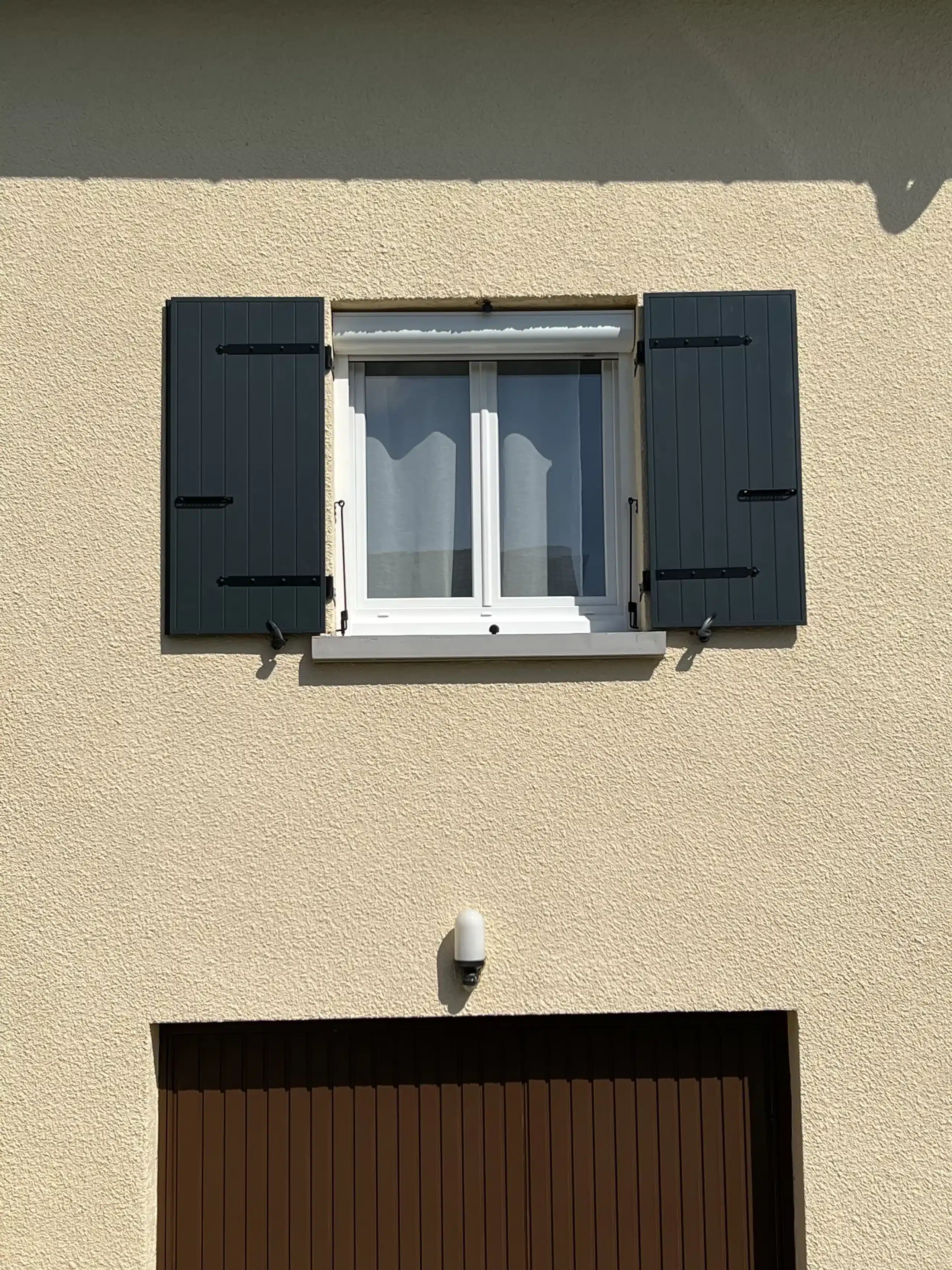 Détail de volets battants alu sur fenêtres à meneaux